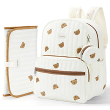 An off-white quilted baby Diaper Bag backpack set with a matching changing pad and small pouch, decorated with a brown teddy bear pattern and brown trim, shown on a white background. #Color_Beige - Bears