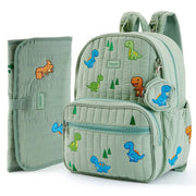 A light sage green quilted baby diaper bag backpack with colorful dinosaur and tree prints, shown alongside a matching zippered pouch and a folded changing pad on a white background. #Color_Green - Dinosaurs